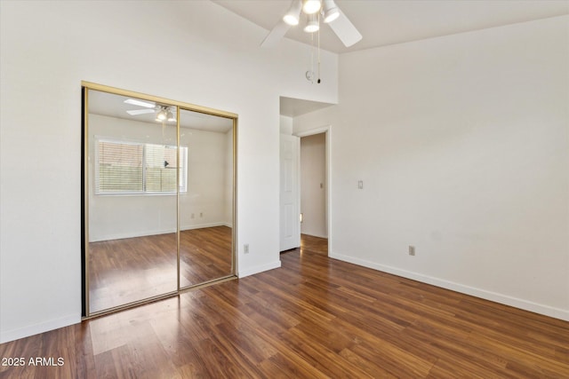 unfurnished bedroom featuring baseboards, a closet, a ceiling fan, and wood finished floors