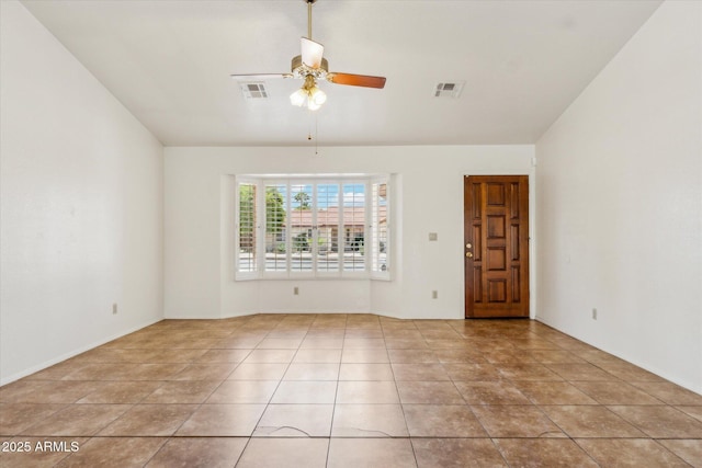 tiled spare room with ceiling fan and visible vents