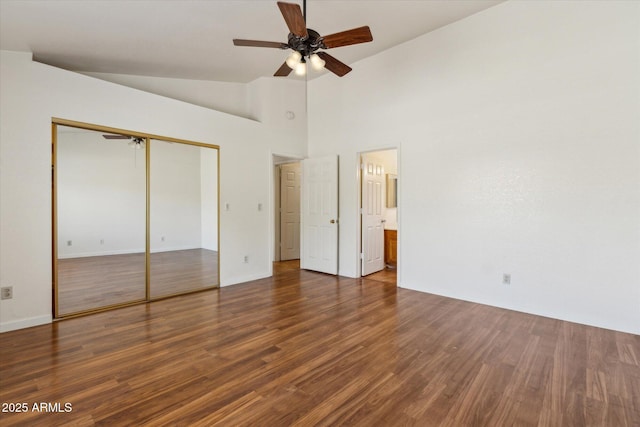 unfurnished bedroom with lofted ceiling, baseboards, a closet, and wood finished floors