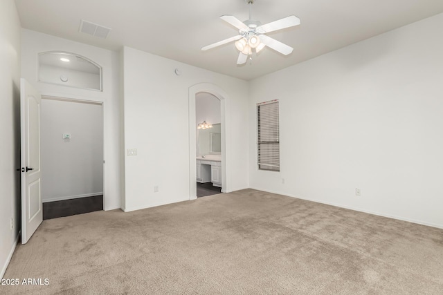 unfurnished bedroom featuring ceiling fan, ensuite bath, and carpet floors