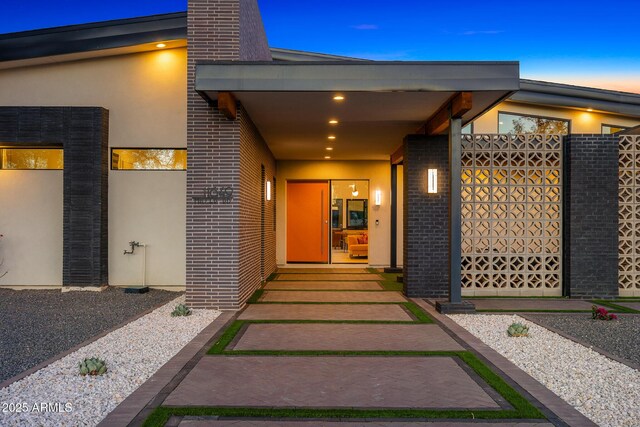 11649 N Miller Rd, Scottsdale, AZ 85260 - view of exterior entry featuring brick siding, stucco siding, and a chimney