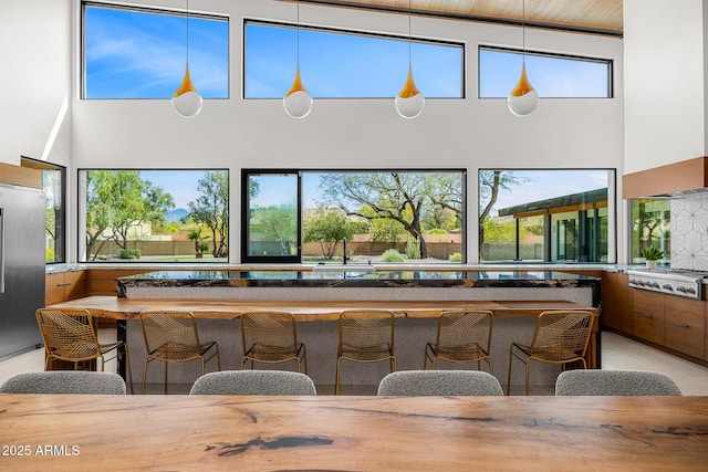 11649 N Miller Rd, Scottsdale, AZ 85260 - bar featuring white gas stovetop, a high ceiling, decorative light fixtures, and high end fridge