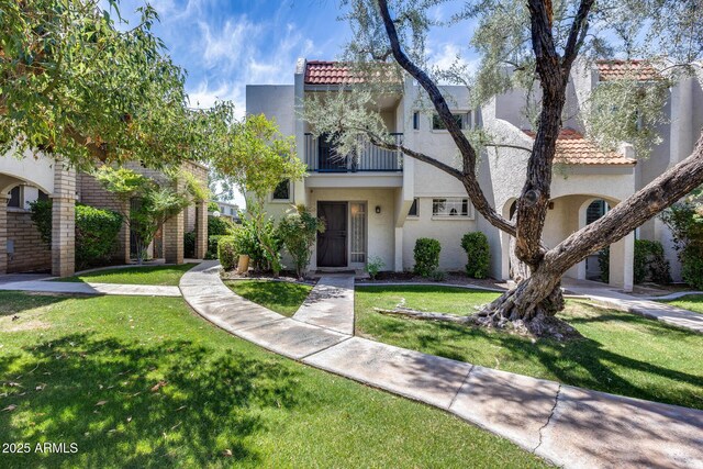 8225 N Central Ave Unit 44, Phoenix, AZ 85020 - view of front of house featuring stucco siding, a front lawn, a tile roof, and a balcony
