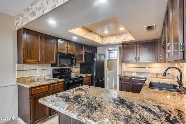 8225 N Central Ave Unit 44, Phoenix, AZ 85020 - kitchen featuring washing machine and clothes dryer, light stone counters, a sink, visible vents, and black appliances