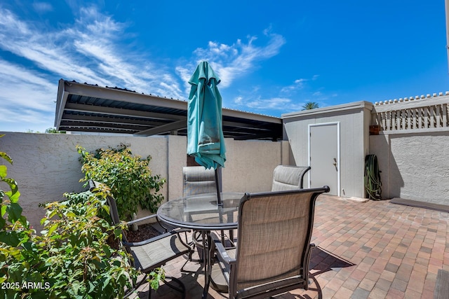8225 N Central Ave Unit 44, Phoenix, AZ 85020 - view of patio featuring an outdoor structure, a fenced backyard, outdoor dining space, and a storage unit