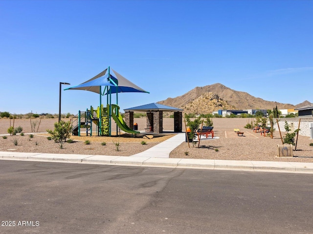 view of front of home featuring playground community and a mountain view