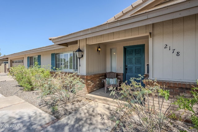 2178 E Golf Ave, Tempe, AZ 85282 - doorway to property with an attached garage, covered porch, and brick siding