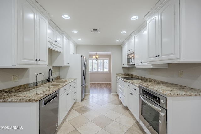 2178 E Golf Ave, Tempe, AZ 85282 - kitchen with stainless steel appliances, white cabinetry, a sink, a chandelier, and baseboards
