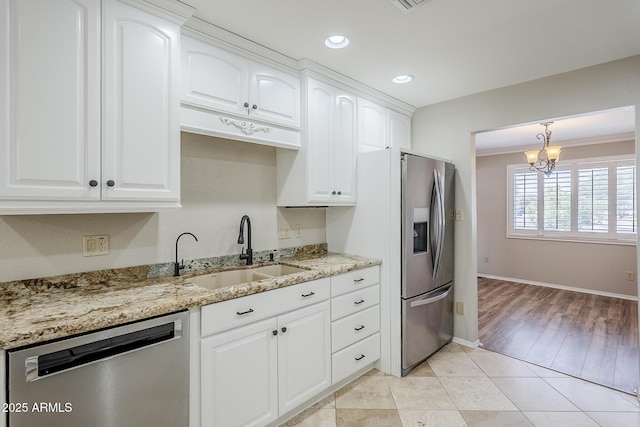 2178 E Golf Ave, Tempe, AZ 85282 - kitchen with stainless steel appliances, a sink, light stone counters, white cabinetry, and a chandelier