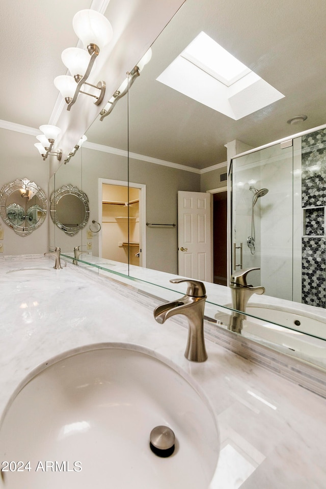 bathroom featuring vanity, a skylight, a shower with shower door, and ornamental molding