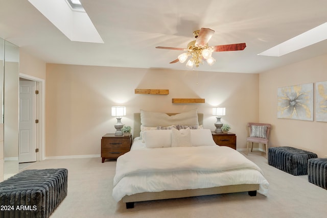 carpeted bedroom with ceiling fan and a skylight