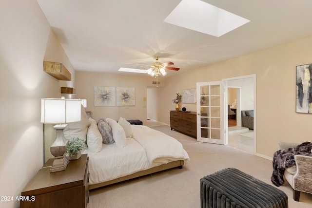 carpeted bedroom featuring ceiling fan and a skylight