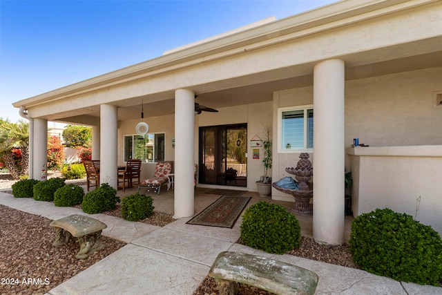 entrance to property with ceiling fan and a patio area