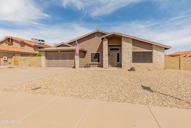 12455 N 71st Ave, Peoria, AZ 85381 - view of front of property with fence, driveway, brick siding, and a garage