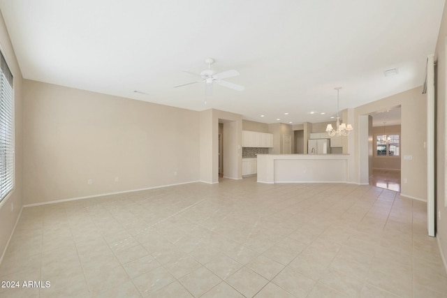 unfurnished living room with ceiling fan with notable chandelier and light tile patterned floors