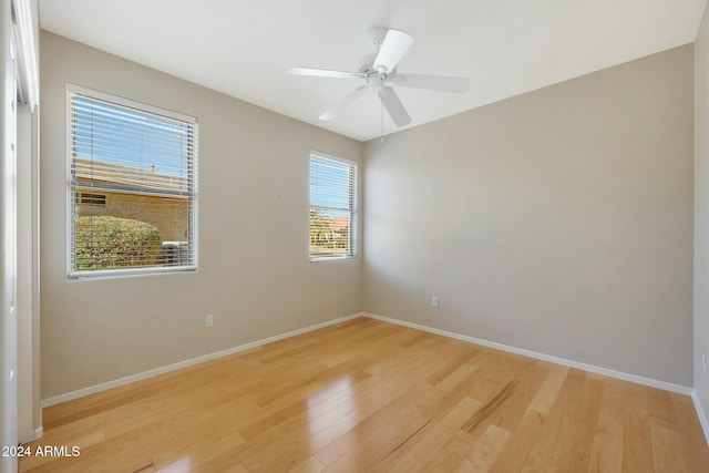 spare room with light hardwood / wood-style flooring, ceiling fan, and a healthy amount of sunlight