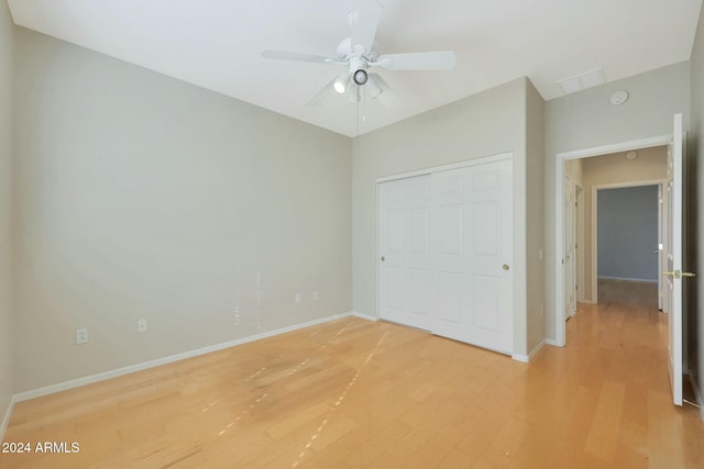 unfurnished bedroom with ceiling fan, light hardwood / wood-style floors, and a closet