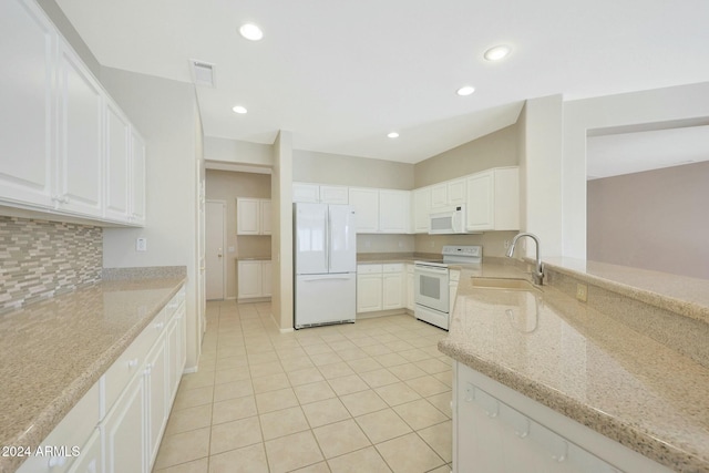 kitchen featuring sink, light tile patterned floors, light stone counters, white appliances, and white cabinets