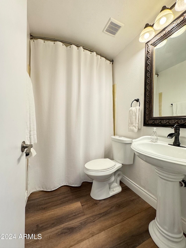 bathroom with wood-type flooring and toilet