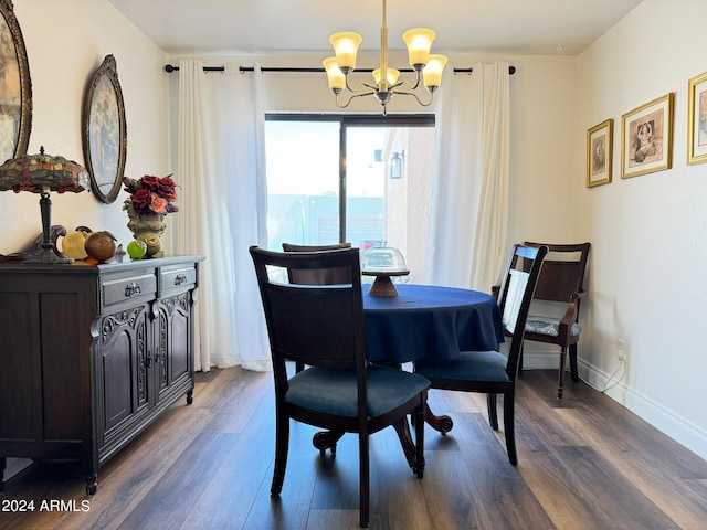 dining area with dark wood-type flooring and a notable chandelier