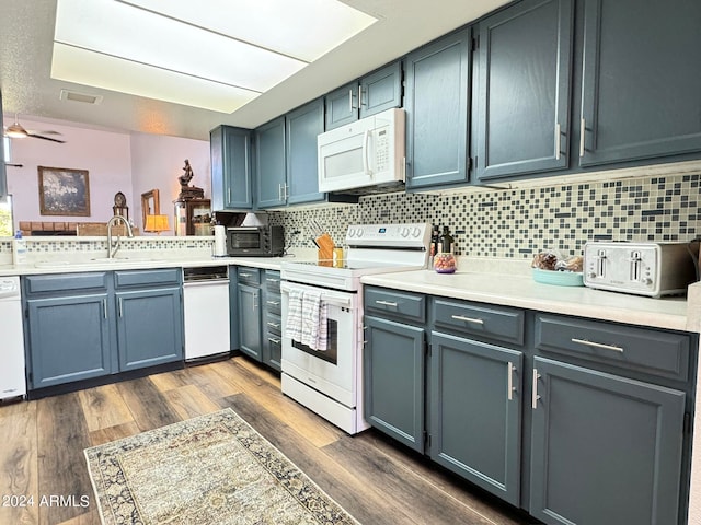 kitchen with backsplash, white appliances, ceiling fan, sink, and dark hardwood / wood-style floors