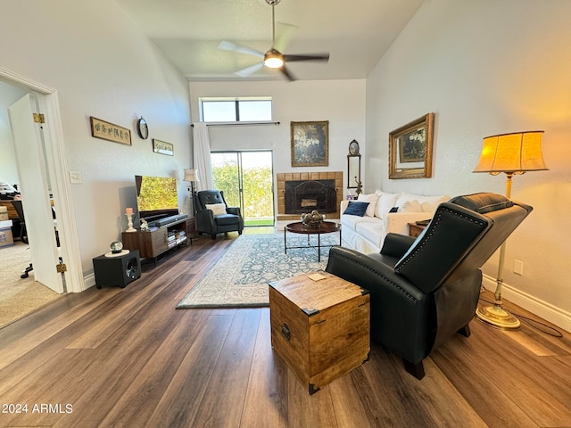 living room featuring a tile fireplace, ceiling fan, high vaulted ceiling, and dark hardwood / wood-style floors