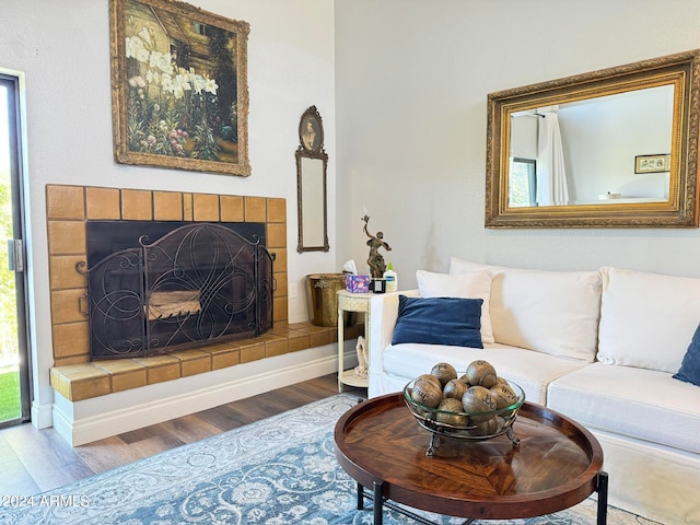 living room featuring wood-type flooring and a tile fireplace