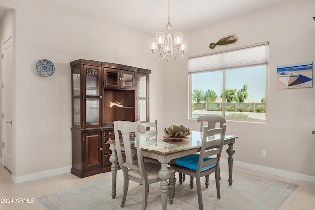 tiled dining room with an inviting chandelier