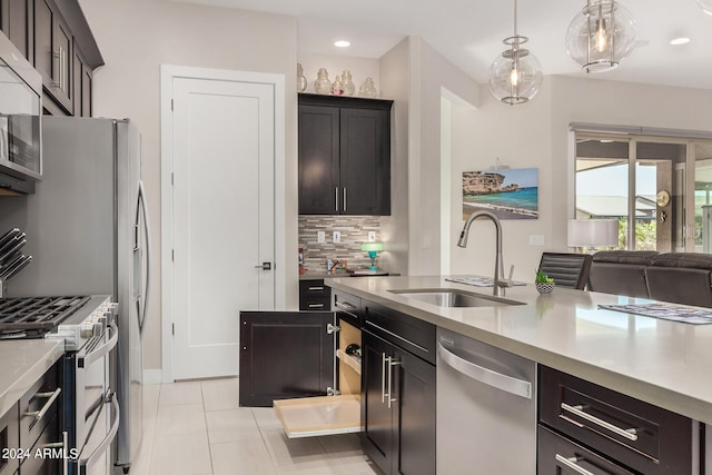 kitchen featuring light tile patterned floors, sink, tasteful backsplash, decorative light fixtures, and appliances with stainless steel finishes