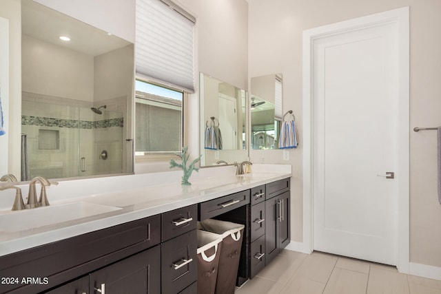 bathroom with walk in shower, vanity, and tile patterned floors