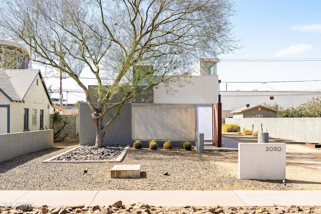 view of front of property with fence and stucco siding