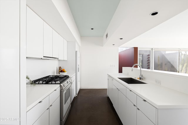 kitchen with visible vents, gas range, light countertops, white cabinetry, and a sink