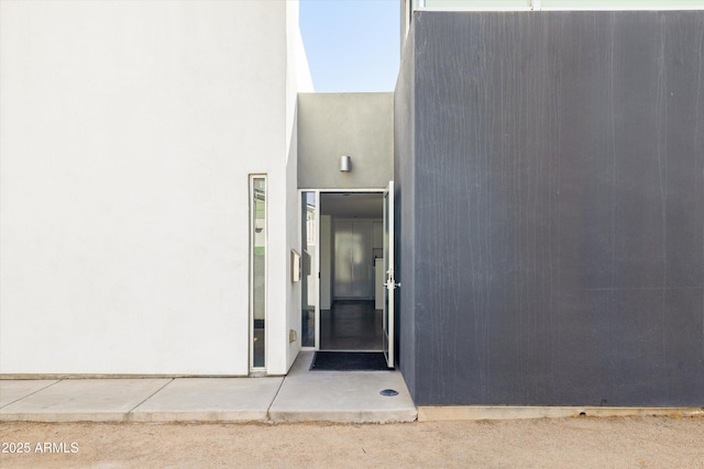 view of exterior entry featuring stucco siding