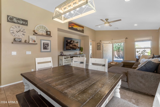 tiled dining space with ceiling fan and lofted ceiling