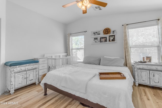 bedroom with ceiling fan, lofted ceiling, and light hardwood / wood-style floors