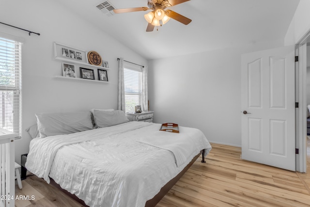 bedroom with ceiling fan, lofted ceiling, and light hardwood / wood-style floors