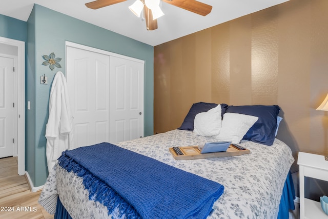 bedroom with hardwood / wood-style flooring, ceiling fan, and a closet