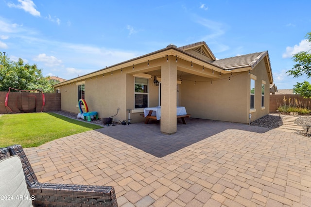 rear view of house with a lawn and a patio