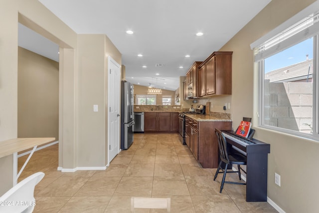 kitchen featuring a healthy amount of sunlight, appliances with stainless steel finishes, light stone countertops, and lofted ceiling