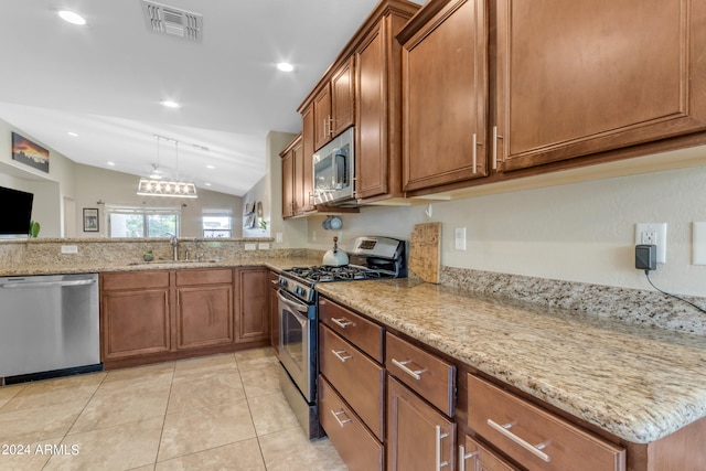 kitchen with appliances with stainless steel finishes, sink, hanging light fixtures, light tile patterned floors, and light stone counters