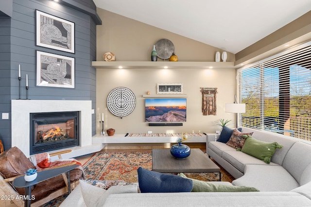 living area with a fireplace and high vaulted ceiling