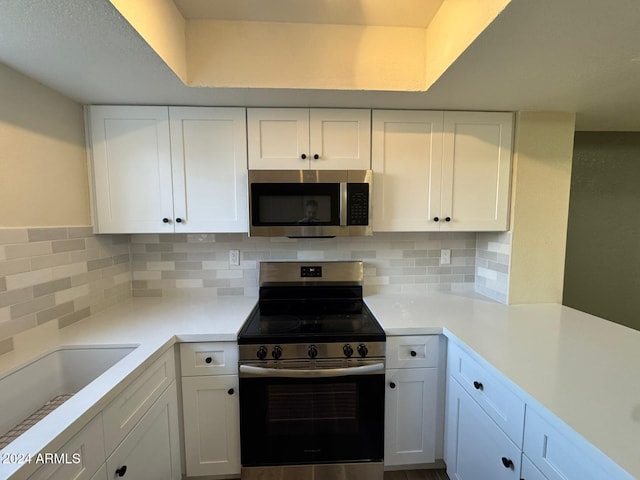 kitchen with white cabinetry, stainless steel appliances, and tasteful backsplash