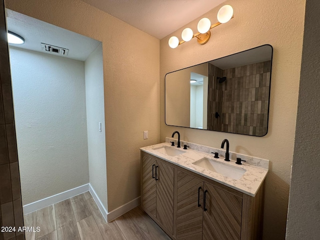 bathroom with vanity, hardwood / wood-style flooring, and a shower