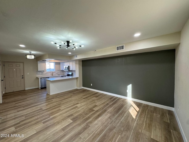 unfurnished living room with sink and light wood-type flooring