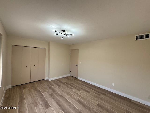 unfurnished bedroom featuring light hardwood / wood-style flooring and a closet