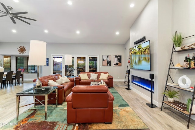 living room featuring french doors, ceiling fan, light hardwood / wood-style flooring, and vaulted ceiling