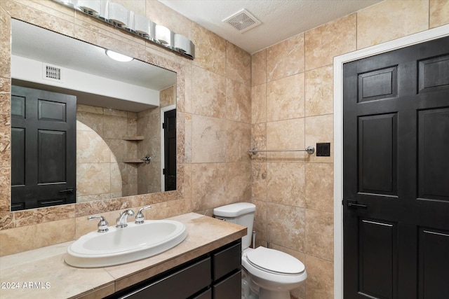 bathroom featuring backsplash, vanity, a textured ceiling, tile walls, and toilet