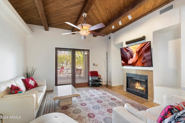 living room featuring a tile fireplace, beam ceiling, ceiling fan, and wood ceiling