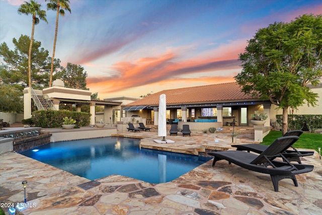 pool at dusk with a patio