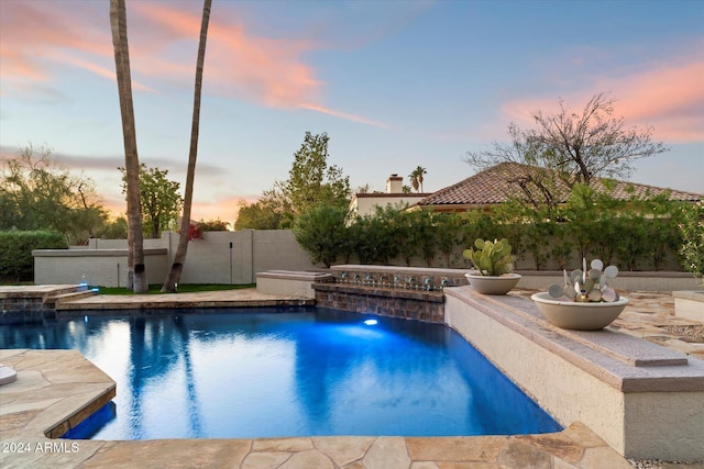 pool at dusk with pool water feature